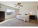 Bright primary bedroom features carpeted floors, a ceiling fan, and a view to the neighborhood at 8852 Ventura St, Commerce City, CO 80022