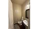 Cozy powder room featuring a pedestal sink, toilet, decorative sign, and modern fixtures at 20678 E Lake Cir, Centennial, CO 80016