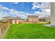 Large fenced backyard featuring green lawn and storage shed at 562 Gallo St, Brighton, CO 80603
