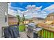 Deck with a grill overlooks a fenced yard with blue skies and green grass at 562 Gallo St, Brighton, CO 80603