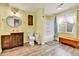 Bright bathroom with a wooden vanity, round mirror, and a shower with a blue and white curtain at 562 Gallo St, Brighton, CO 80603
