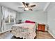 Cozy bedroom with a ceiling fan, a window with curtains, and wood-look flooring at 562 Gallo St, Brighton, CO 80603