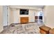 Carpeted living room features a large TV and doorway to the kitchen at 562 Gallo St, Brighton, CO 80603