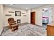 Carpeted living room features a chair, shelves, and a doorway to the bedroom at 562 Gallo St, Brighton, CO 80603