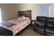Bedroom with a wooden bed frame, a floral comforter and a leather love seat at 449 Lowell Blvd, Denver, CO 80204