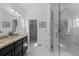 Bright bathroom features a double vanity with granite counters, stylish tile floors, and a glass enclosed shower at 17960 Weymouth Ave, Parker, CO 80134