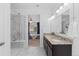 Bright bathroom features a double vanity with granite counters, stylish tile floors, and glass enclosed shower with bench at 17960 Weymouth Ave, Parker, CO 80134