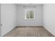 This cozy bedroom has a window letting in light and neutral carpet at 17960 Weymouth Ave, Parker, CO 80134