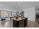 Bright open floor plan featuring modern kitchen with island and sink overlooking the living area at 17960 Weymouth Ave, Parker, CO 80134