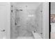 A sleek, glass-enclosed shower featuring marble tiling, a built-in bench and modern fixtures at 17960 Weymouth Ave, Parker, CO 80134