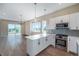 Modern kitchen with stainless steel appliances, white cabinets, quartz counters, and hardwood floors at 8500 W 62Nd Ave # D, Arvada, CO 80004