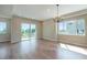 Bright living room featuring hardwood floors, a modern chandelier, and large sliding glass doors to a balcony at 8500 W 62Nd Ave # D, Arvada, CO 80004