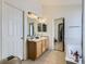 Bright bathroom featuring a double sink vanity, tiled floor, and a soaking tub at 24704 E Chenango Dr, Aurora, CO 80016