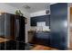 Well-lit kitchen with modern black appliances and stylish navy blue cabinetry at 1050 N Corona St # 312, Denver, CO 80218