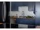 Close-up of navy blue kitchen cabinets, stainless steel appliances, and wood countertops at 1050 N Corona St # 312, Denver, CO 80218