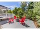 Relaxing backyard patio with red Adirondack chairs around a fire pit, perfect for outdoor entertaining, next to a white deck at 6258 Lancaster Ave, Castle Rock, CO 80104