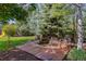 A serene backyard featuring a tranquil pond and wooden deck with a wooden bench, all nestled amidst lush landscaping and mature trees at 6258 Lancaster Ave, Castle Rock, CO 80104