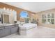 Large bathroom with a soaking tub, dual vanities, and granite counters at 6258 Lancaster Ave, Castle Rock, CO 80104