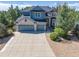 A stunning two-story home with a blue and stone facade, complemented by a spacious driveway and a three-car garage at 6258 Lancaster Ave, Castle Rock, CO 80104