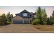 A charming exterior view of a stone and blue two-story house with a spacious driveway leading to a three-car garage at 6258 Lancaster Ave, Castle Rock, CO 80104