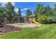 Backyard playground with a swing set, slide, and playhouse set in a landscaped yard at 6258 Lancaster Ave, Castle Rock, CO 80104