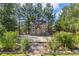 A backyard playhouse surrounded by mature trees, greenery, and a stone pathway at 6258 Lancaster Ave, Castle Rock, CO 80104