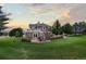 Backyard with a two-story home, patio, outdoor dining area, mature trees, and a well-kept lawn at 5604 Singletree Ln, Parker, CO 80134