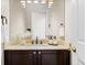 Bathroom with granite countertop, dark wood vanity, decorative hardware, and stylish fixtures at 5604 Singletree Ln, Parker, CO 80134