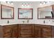 Bathroom with granite countertops, dark cabinets, and three-sided mirror arrangement at 5604 Singletree Ln, Parker, CO 80134