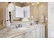 Bathroom featuring double sinks with granite countertops and a large framed mirror at 5604 Singletree Ln, Parker, CO 80134