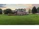 Expansive two-story home featuring brick and siding exterior with a well-manicured lawn at sunset at 5604 Singletree Ln, Parker, CO 80134