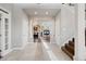 Bright foyer with staircase provides access to living spaces and a view of fireplace at 5604 Singletree Ln, Parker, CO 80134
