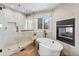 This luxurious bathroom offers a soaking tub, walk-in shower, and a cozy fireplace at 5604 Singletree Ln, Parker, CO 80134