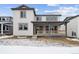 Backyard view featuring covered patio and modern home exterior in winter landscape at 16634 W 93Rd Way, Arvada, CO 80007