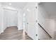 Bright hallway featuring hardwood floors, neutral-colored walls, and an open door to the living area at 16634 W 93Rd Way, Arvada, CO 80007