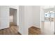 Hallway area featuring hardwood floors, neutral-colored walls, and an open door to the living area at 16634 W 93Rd Way, Arvada, CO 80007