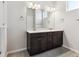 Bathroom with a double vanity, dark wood cabinets and modern lighting at 457 Interlocken Blvd # 101, Broomfield, CO 80021
