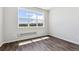 Bright bedroom featuring large window with neighborhood view, and modern wood-look flooring at 457 Interlocken Blvd # 101, Broomfield, CO 80021