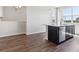 Kitchen island with dark cabinets, white countertop, stainless steel dishwasher and wood flooring at 457 Interlocken Blvd # 101, Broomfield, CO 80021
