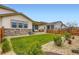 Lush backyard featuring a well-maintained lawn, stone accents, wooden fence, and a cozy patio area at 3461 N Buchanan Way, Aurora, CO 80019
