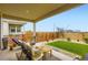 Relaxing covered patio featuring comfortable outdoor seating, a manicured lawn, and a stylish privacy fence at 3461 N Buchanan Way, Aurora, CO 80019