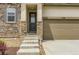 Close up of home showcasing stone facade, tan siding, attached garage, and front entryway at 3461 N Buchanan Way, Aurora, CO 80019
