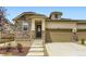 Charming home featuring a stone facade, tan siding, attached garage, and well-manicured landscaping at 3461 N Buchanan Way, Aurora, CO 80019
