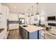 Open kitchen featuring stainless steel appliances and an island with bar seating that flows into the living room at 3461 N Buchanan Way, Aurora, CO 80019
