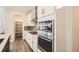 Modern kitchen featuring stainless steel appliances and white cabinetry, with pantry door to the left at 3461 N Buchanan Way, Aurora, CO 80019