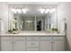 Bathroom vanity featuring double sinks, granite countertops, white cabinets, and large mirror at 7257 S Millbrook Ct, Aurora, CO 80016