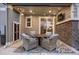 Relaxing covered patio featuring outdoor seating, string lights, tv, and stone accent wall at 7257 S Millbrook Ct, Aurora, CO 80016