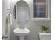 Clean powder room with modern fixtures, pedestal sink, and natural light at 7257 S Millbrook Ct, Aurora, CO 80016