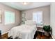 Bright bedroom with hardwood floors, ample natural light, and cozy white bedding at 745 S Utica St, Denver, CO 80219