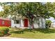 Quaint home exterior featuring a red front door, green lawn, and mature landscaping at 745 S Utica St, Denver, CO 80219